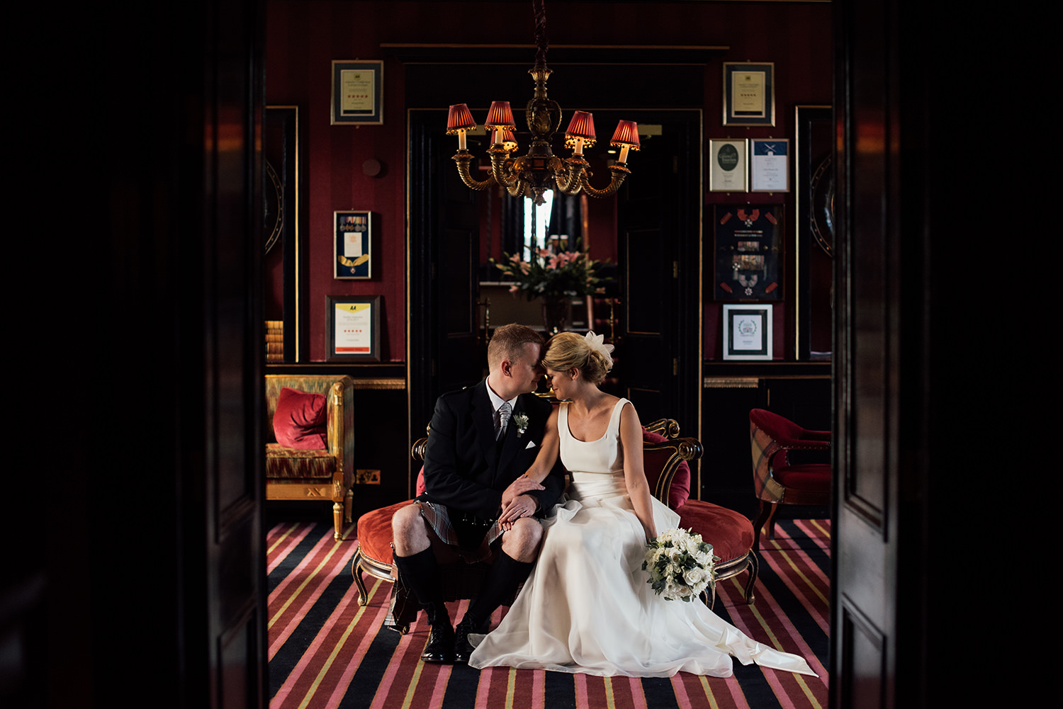 Edinburgh couple posing inside Prestonfield Hote, wedding venue in Edinburgh.