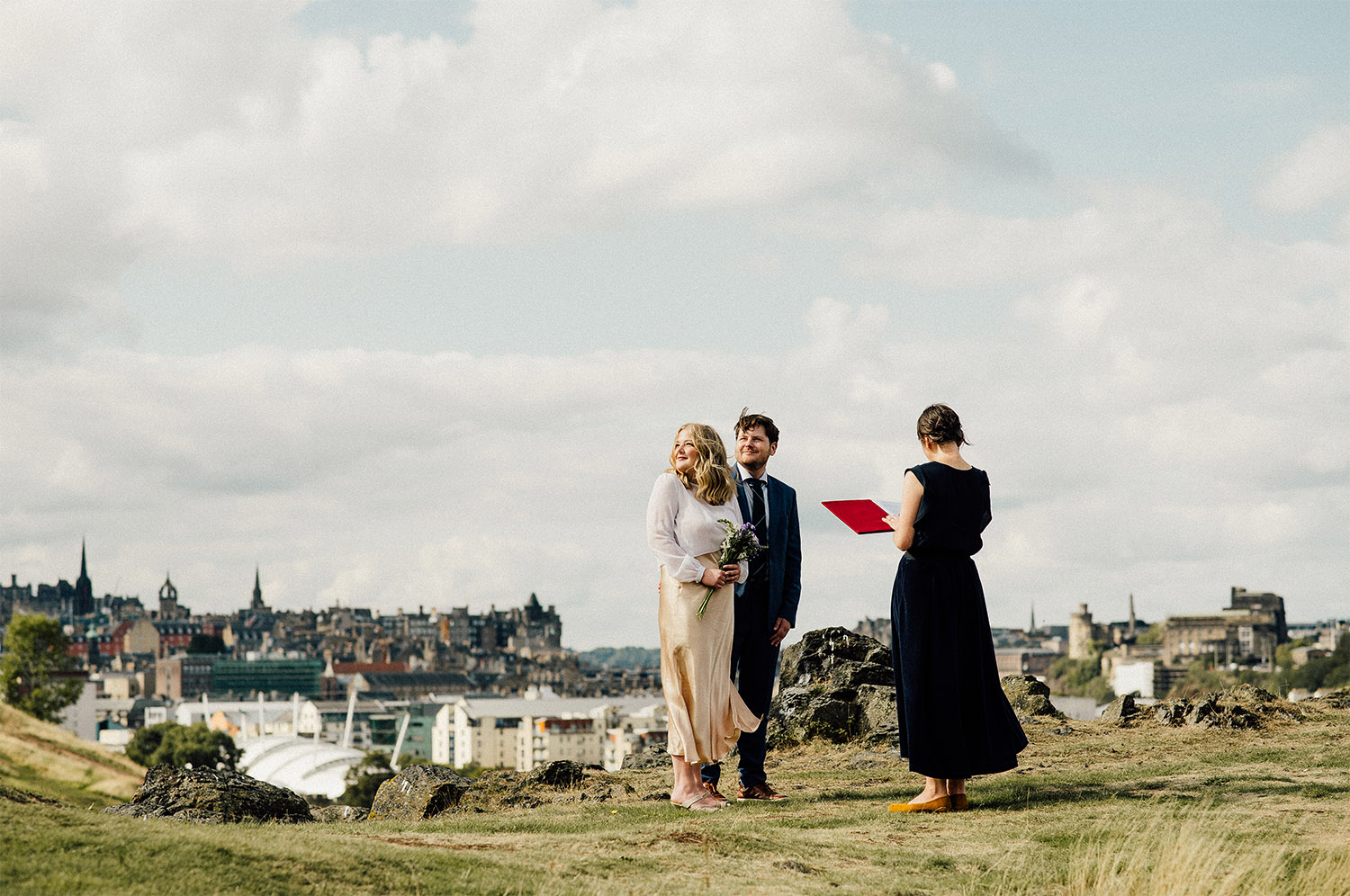 Hannah & Nick standing on top of the hill in Edinburgh ready to say their wedding vows.