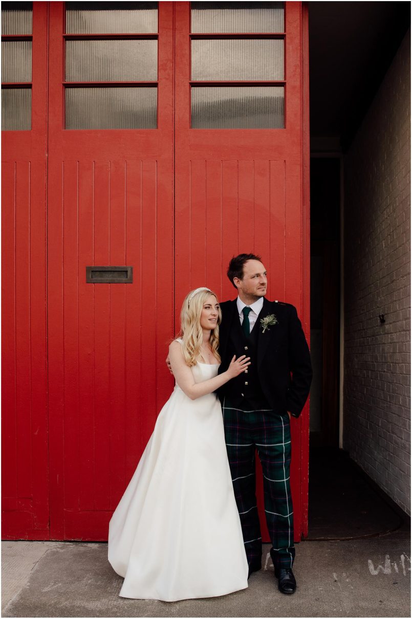 Couple standing outside the Timberyard on their wedding day.