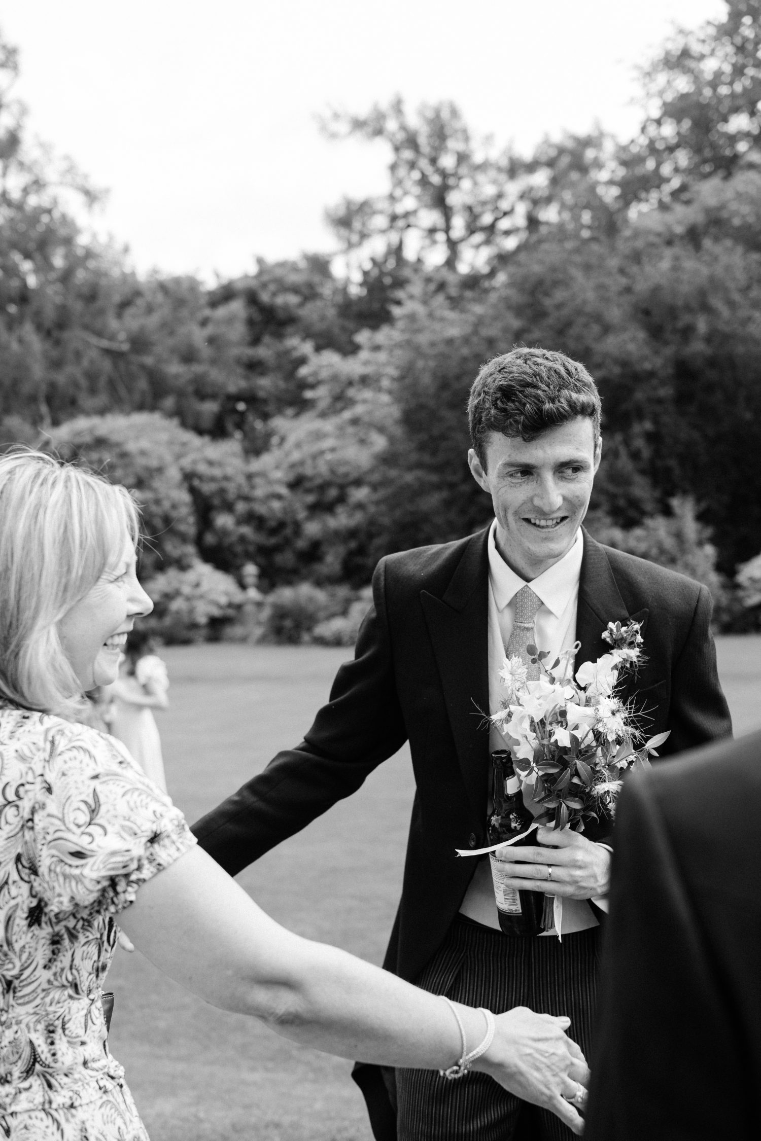 Photo of a groom holding wedding bouquet.