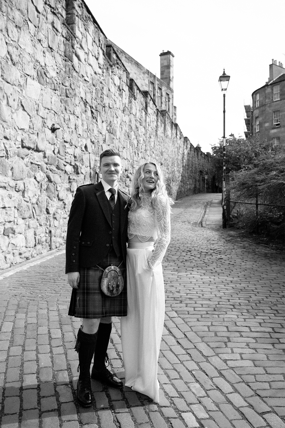 Bride and groom posing for the photos on the little lane behind the Vennel.