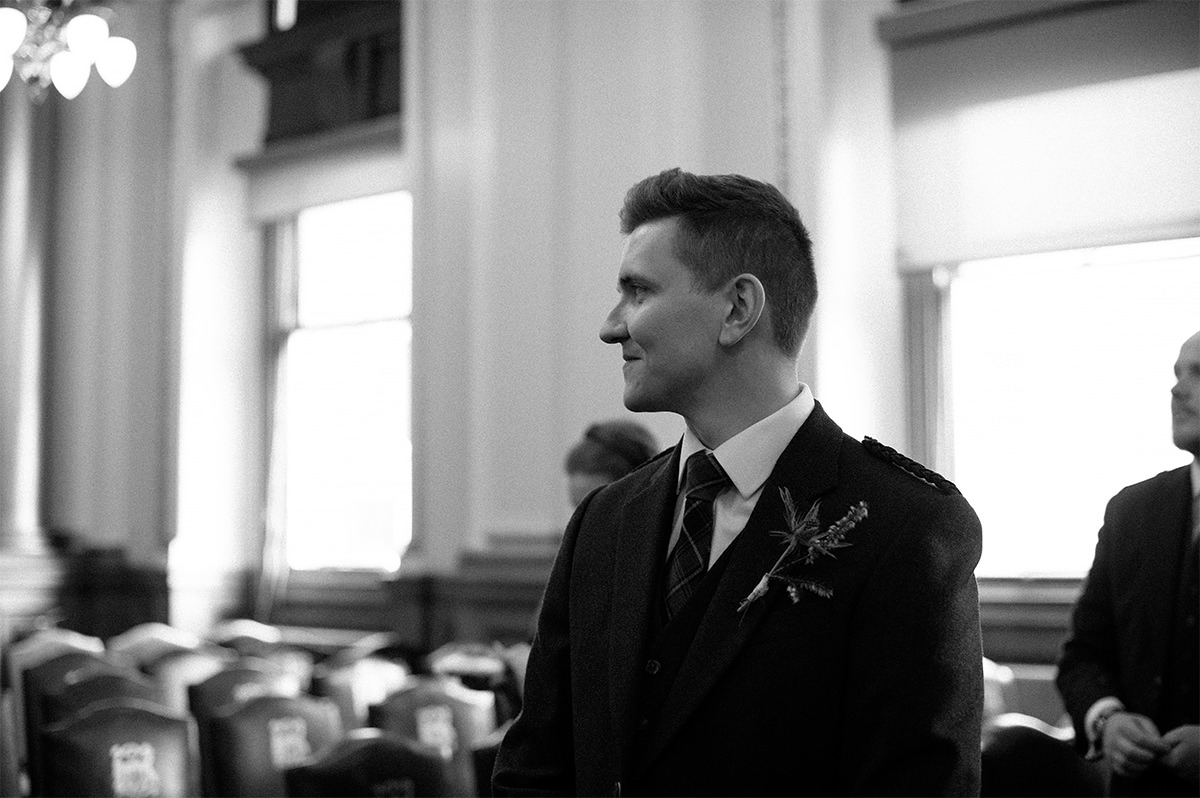 Stuart looking at his bride walking down the aisle at the City