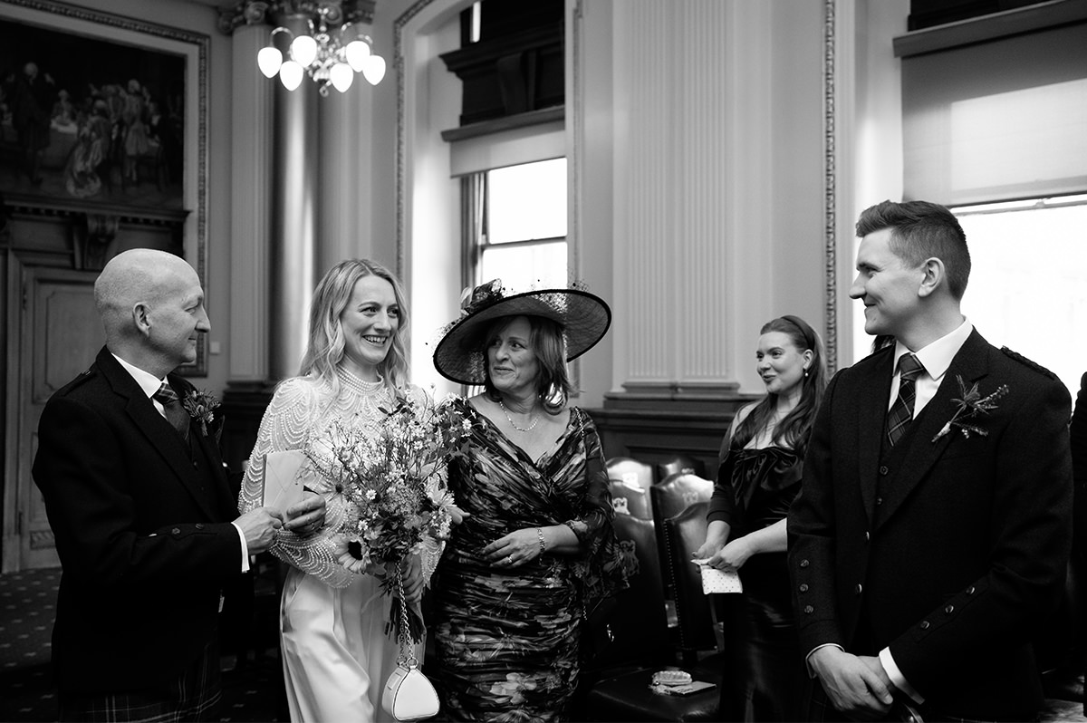 Bride walking with her parents down the aisle for a ceremony at the City chambers.