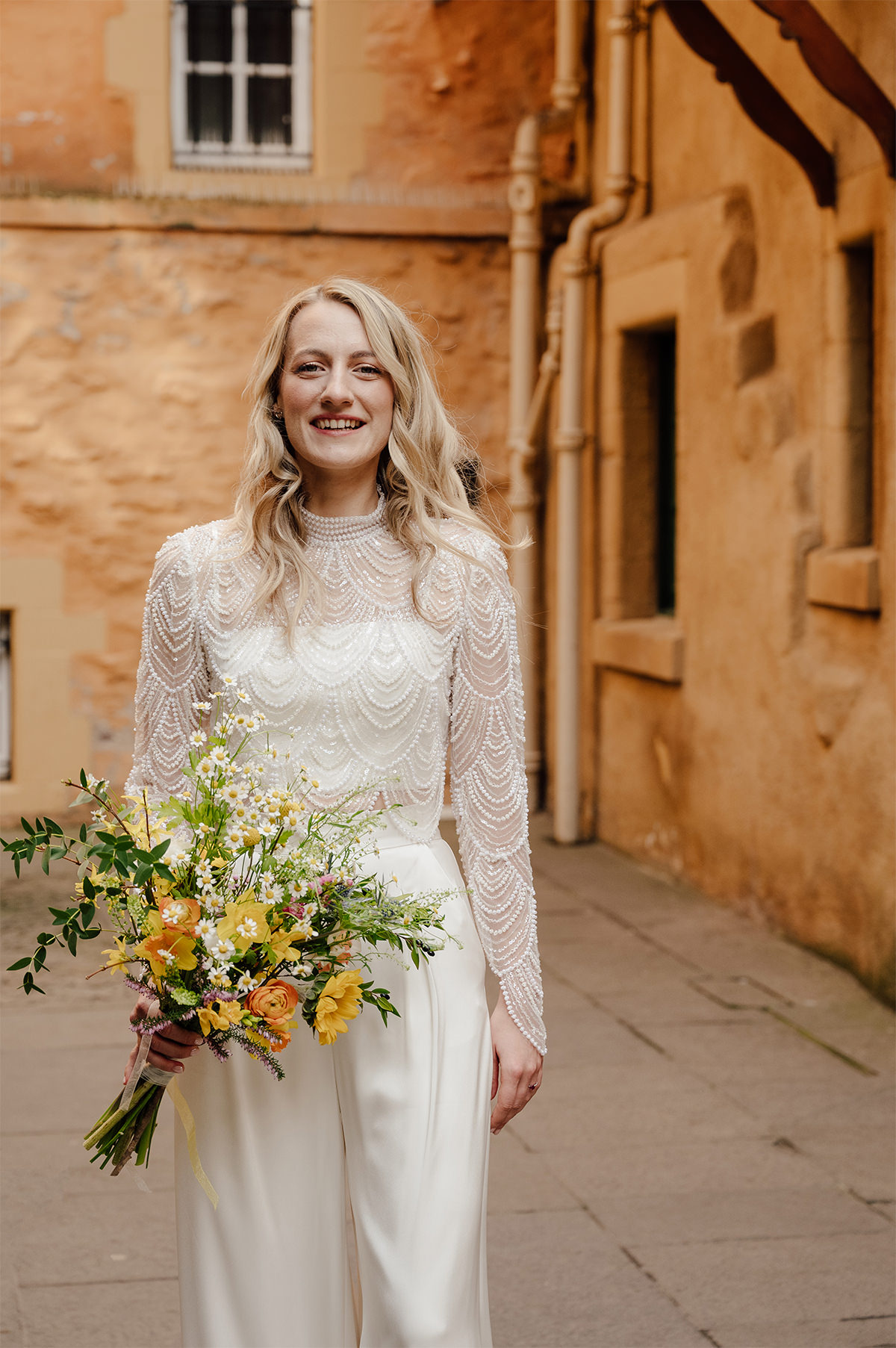 Bride wearing a wedding jumpsuit complemented with Spring wedding bouquet.