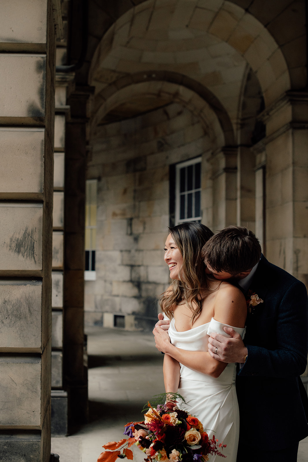 Samantha and Padraig standing under arches in the Parliament Square.