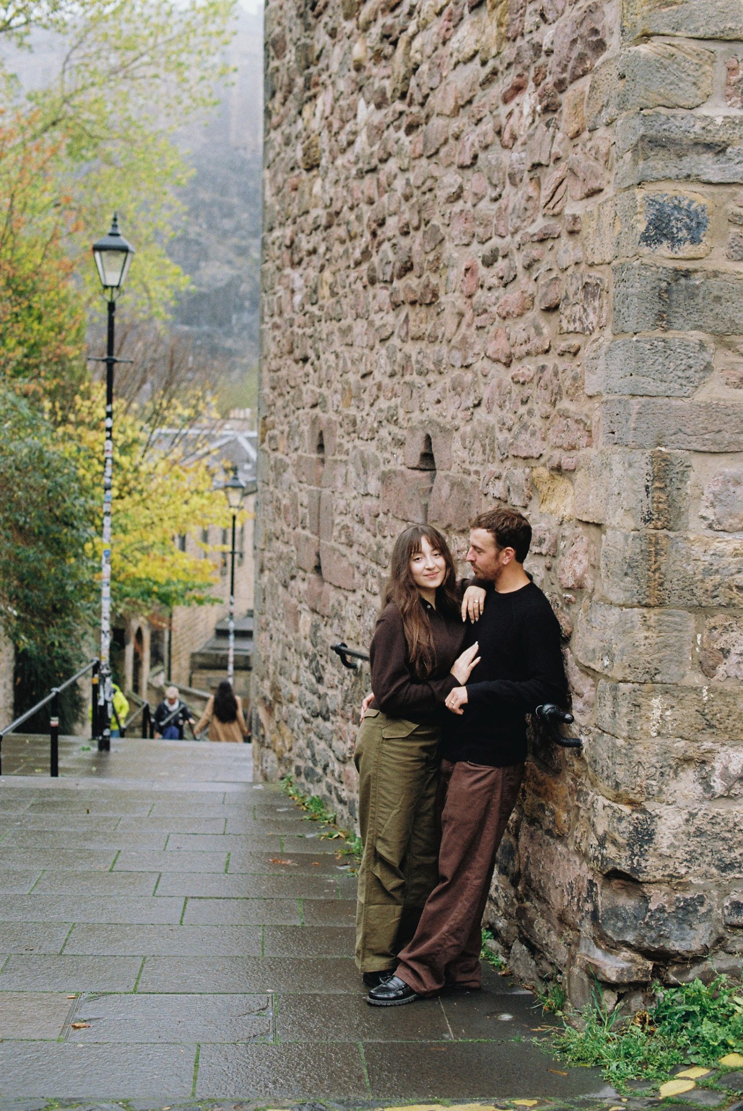 A photo of a couple laughing during analogue photography session in Edinburgh.