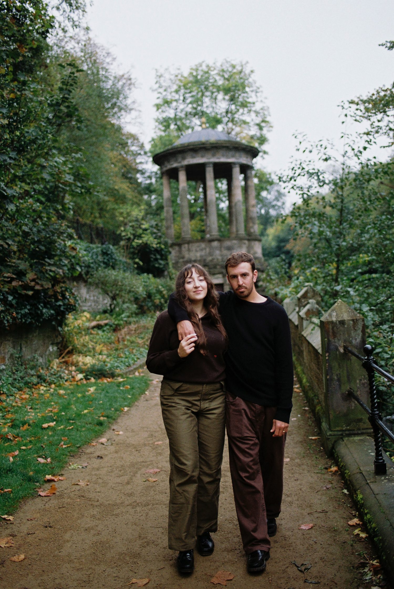 Sara and Brandon walking hand in hand through Stockbridge, Edinburgh captured on 35mm film