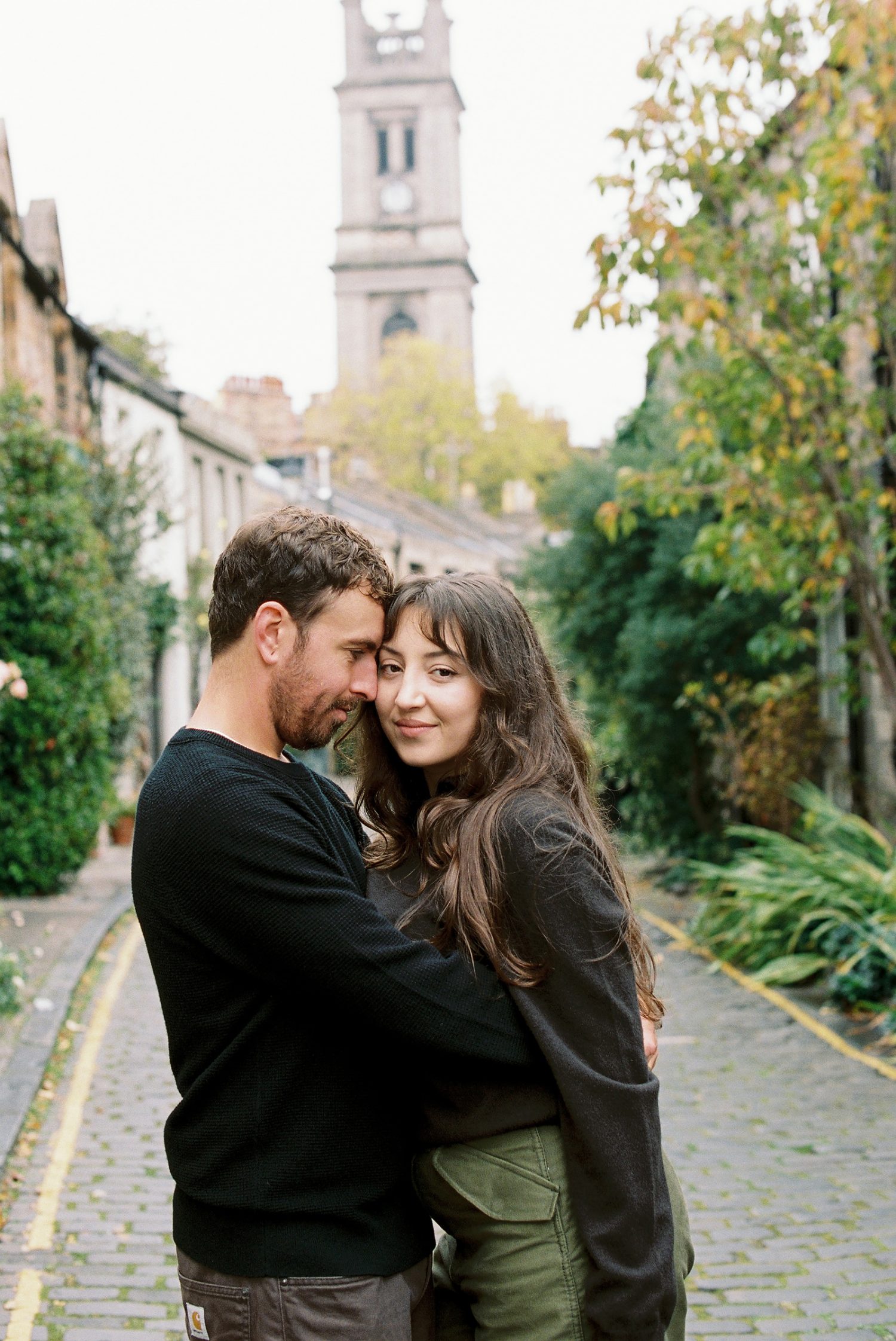 Cinematic 35mm film image of Sara and Brandon exploring historic Edinburgh streets.