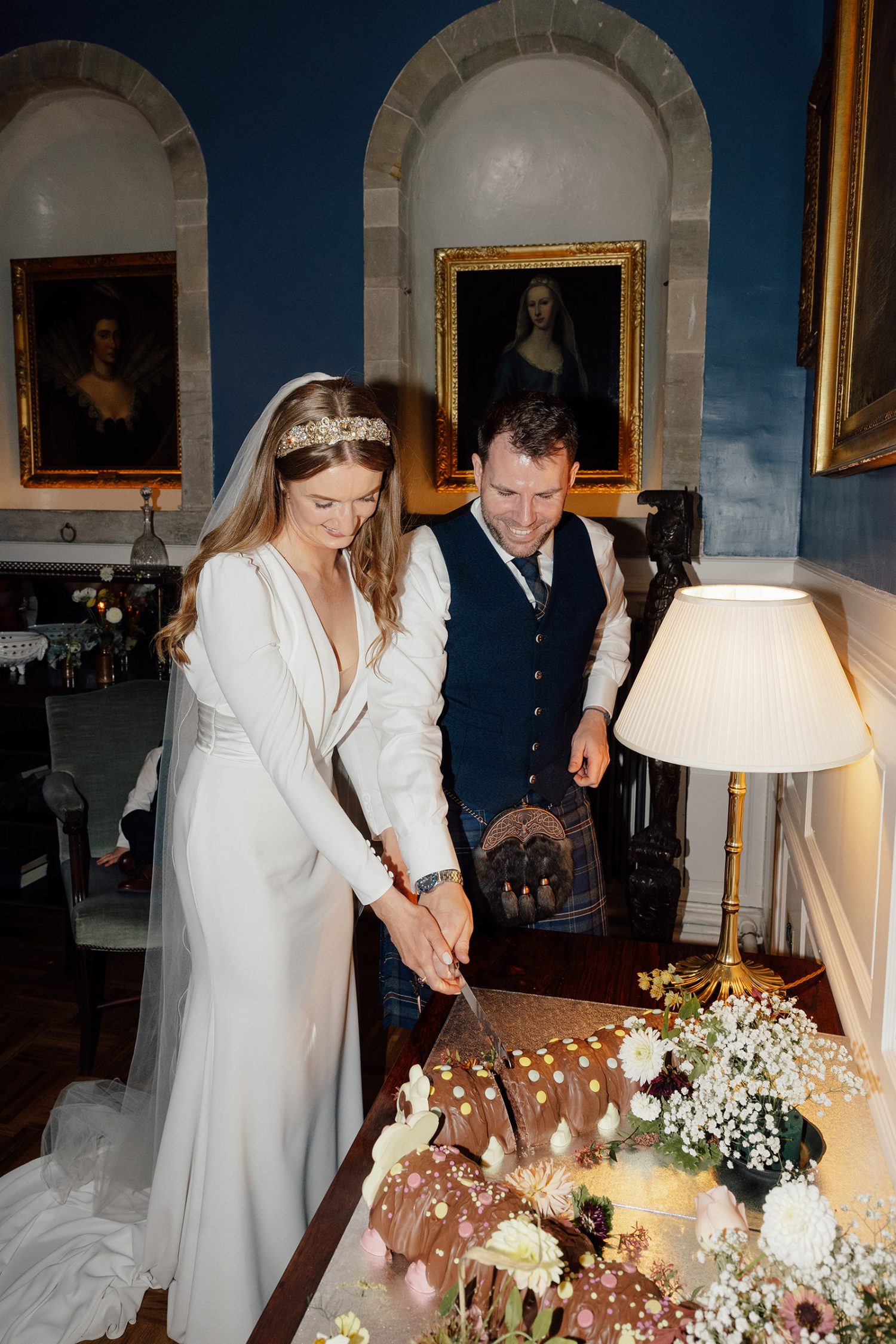 Katy and Ali cutting the cake after their wedding meal.