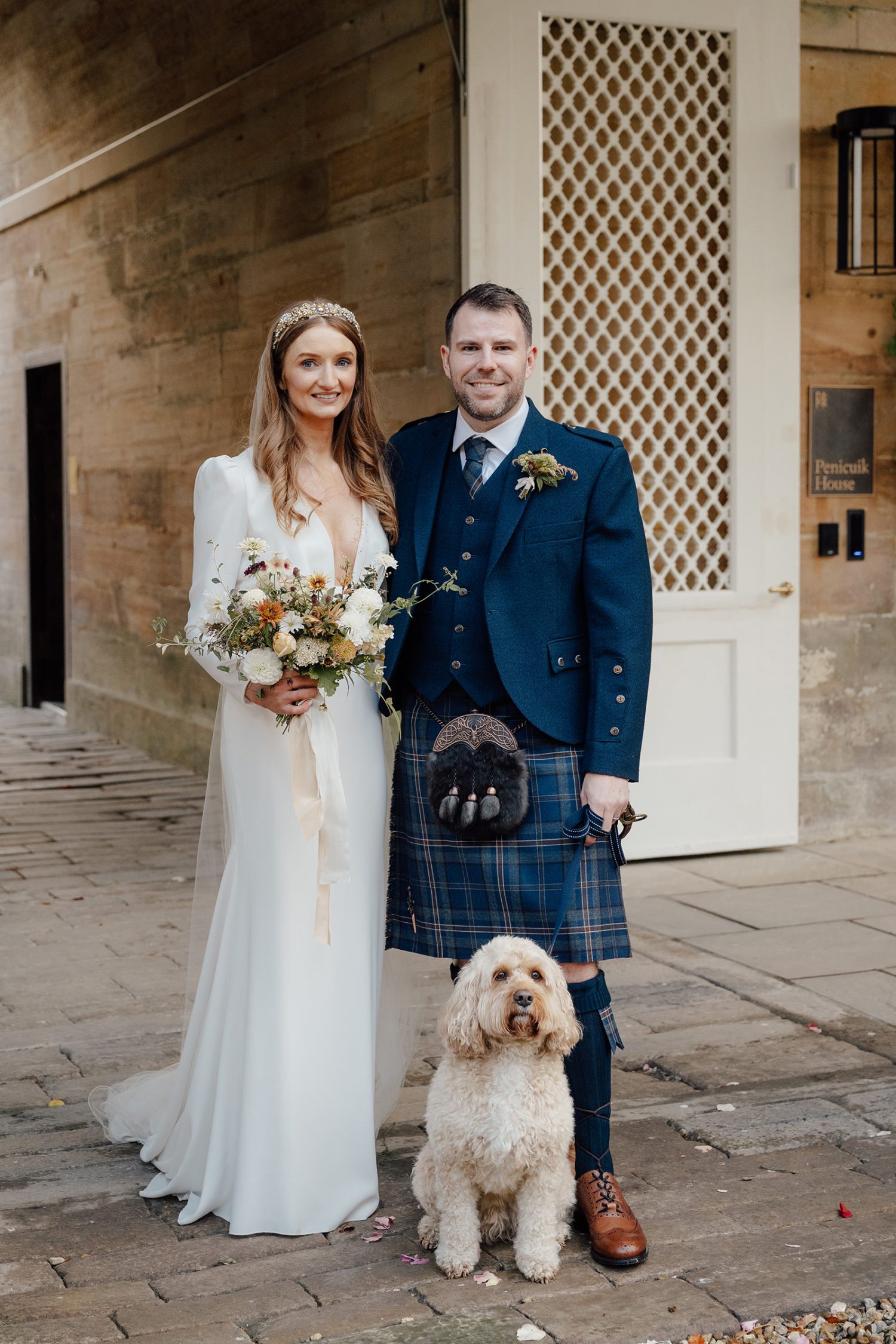 Couple just married at the Penicuik House posing with their dog for the photos.